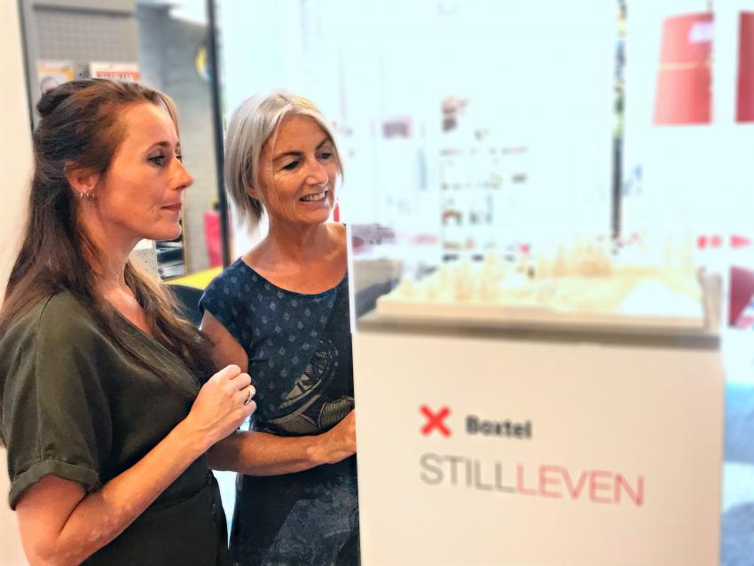 2 vrouwen bij een vitrine over Boxtel stilleven