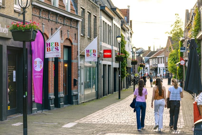Winkelstraat met bloemen aan lantaarnpalen