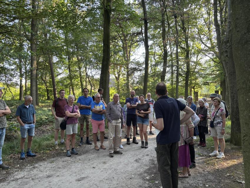 Een groep mensen luistert naar een gids in natuurgebied Sparrenrijk.