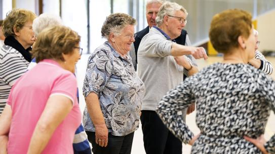 Ouderen staan in een groep, klik voor een vergroting