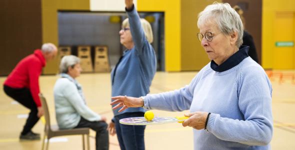 Vier ouderen die oefeningen doen in een gymzaal