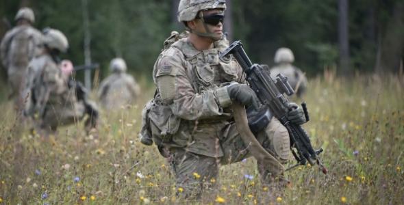 Militairen met wapens staan in een veld