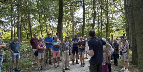 Een groep mensen luistert naar een gids in natuurgebied Sparrenrijk.