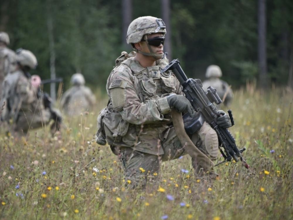 Militairen met wapens staan in een veld